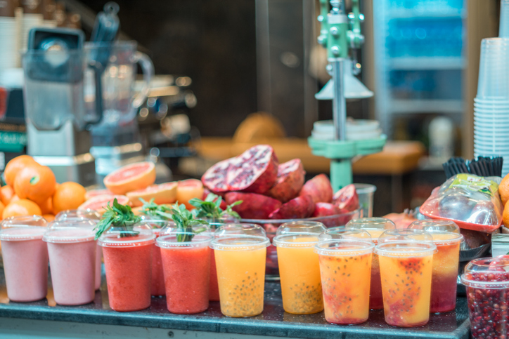 Fresh blended fruit smoothies of various colors and tastes shops for produce in food market Fresh blended fruit smoothies of various colors and tastes shops for produce in food market